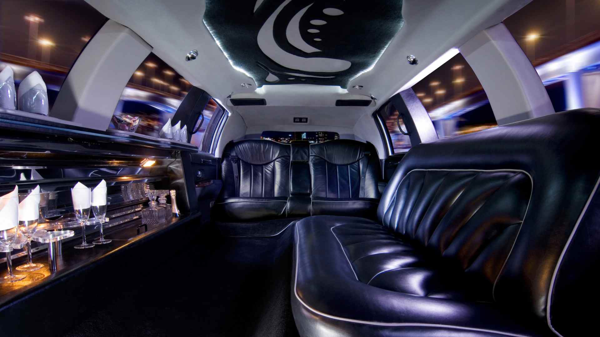 Luxury Limousine Interior - Premium Black Leather Seating and Bar Luxurious limousine interior with black leather seats ambient lighting and bar setup