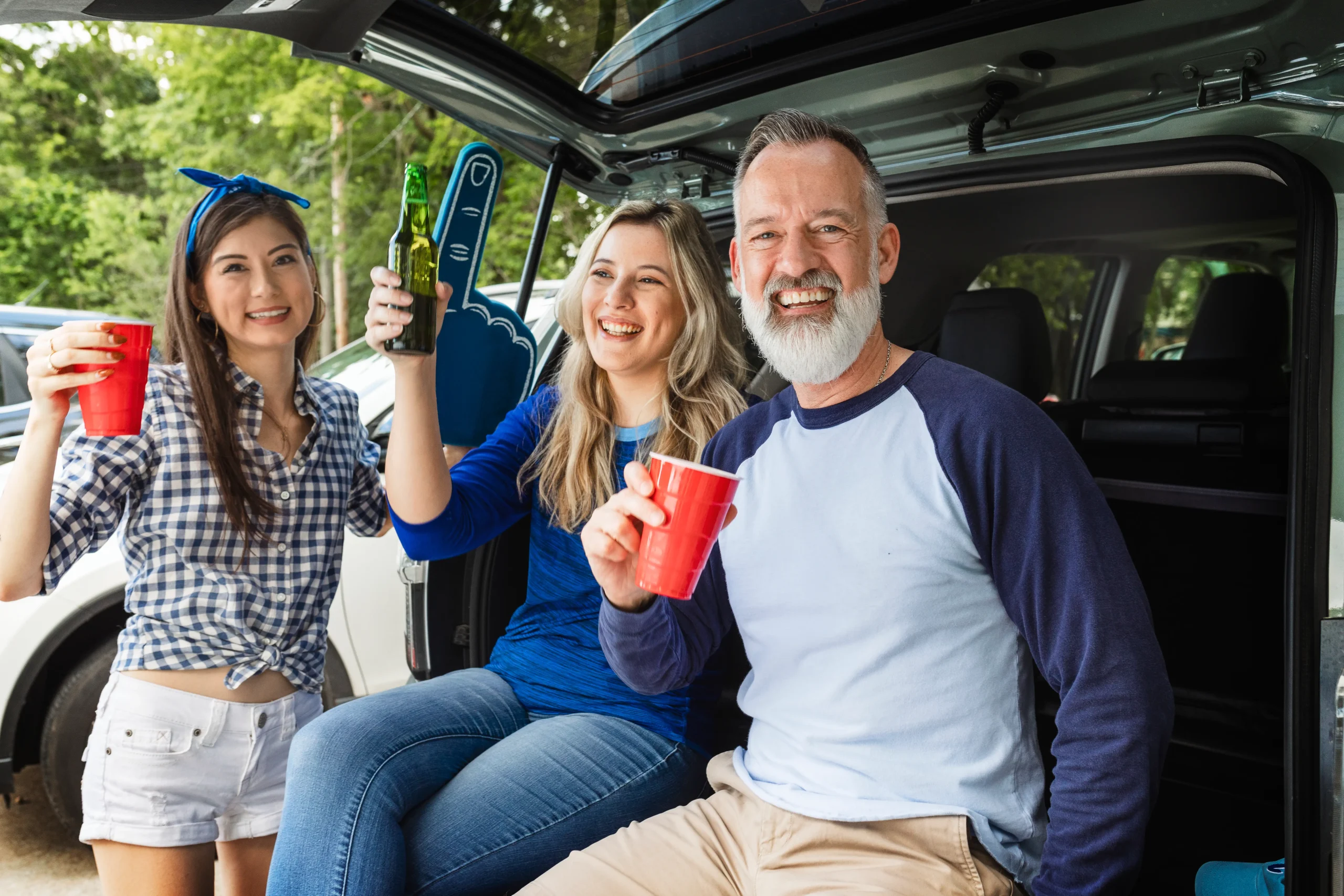 Happy group of friends enjoying drinks and a tailgate party as part of their niagara wine tour experience.
